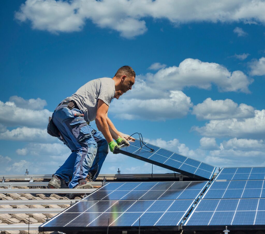 2 Männer platzieren PV-Modul auf einem Hausdach